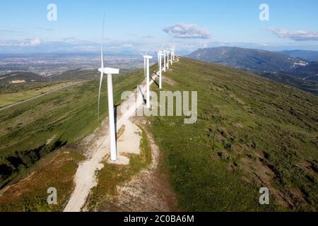 Aerial view of windmills farm for renewable energy production on beautiful blue sky. Wind power turbines generating clean renewable energy for sustainable development. High quality 4k footage.