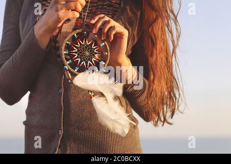 Brunette woman with long hair holding dream catcher Stock Photo