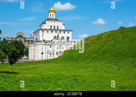 The ruins of the medieval earthen wall - Kozlov Val (rampart), covered with lawn in front of historical building of Golden Gate with barbican church, Stock Photo