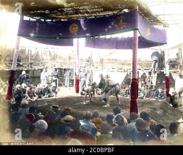 [ 1880s Japan - Sumo at Buddhist Temple ] — Sumo wrestlers in an outside arena at Eko-in Temple (回向院) in Ryogoku, Tokyo ready to start a bout.  The temple was known as a sumo wrestling venue during the Edo (1603-1868) and Meiji (1868-1912) periods.  The first bout was held here in September 1768. From October 1833 (Tenpo 4) to 1909 (Meiji 42), the period of “Eko-in Sumo” (回向院相撲), all sumo tournaments were held at the temple.  19th century vintage albumen photograph. Stock Photo