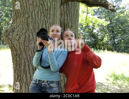 woman with the camera and the man shows upward Stock Photo