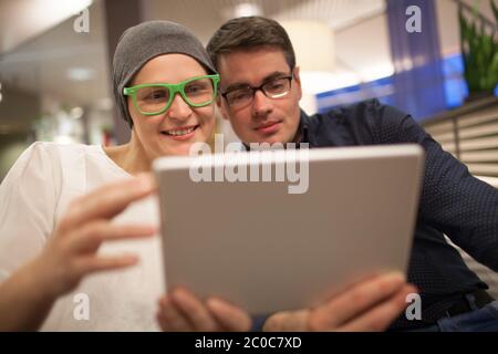 Man and woman using electronic tablet in the restaurant Stock Photo