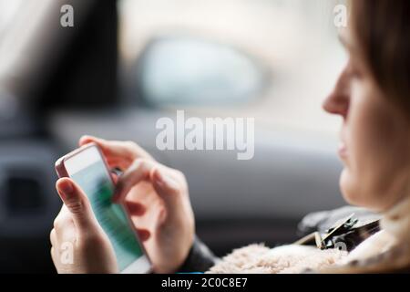 Woman uses smartphone in the car Stock Photo