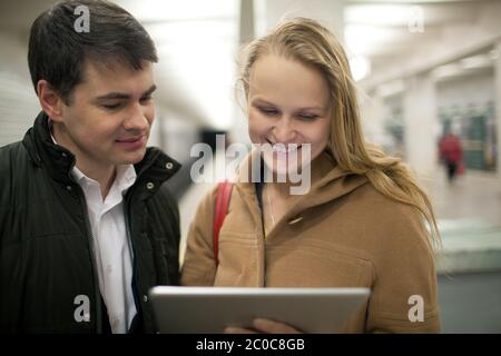Young couple using tablet computer in underground Stock Photo