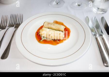 An image of two spring rolls on hot sauce Stock Photo