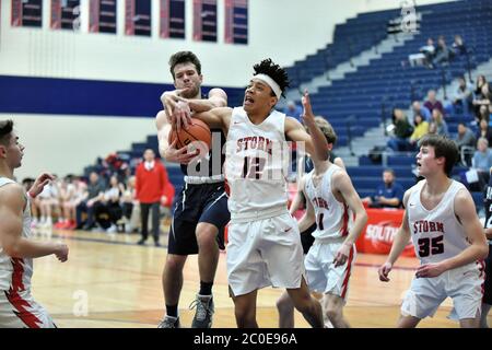 Opposing players battling for possession of the ball during a scramble under the basket. USA. Stock Photo