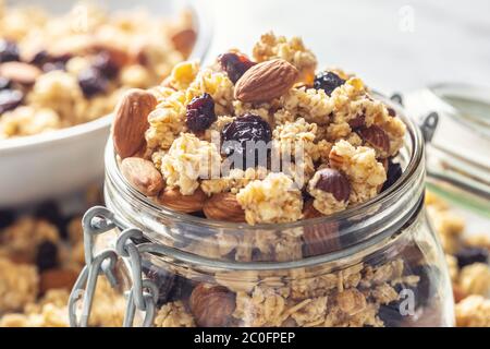 Jar of muesli with nuts, almonds grapes and dried fruits - closeup Stock Photo