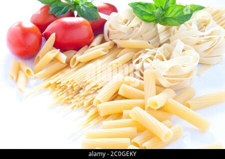 Pasta of various sizes with tomato and basil Stock Photo
