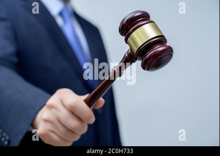 Male businessman holding a gavel in hand. justice and auction concept. Stock Photo