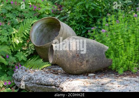 Two large vase decorating a fresh green garden with purple flowers, Garden decoration cocnept Stock Photo