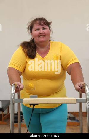 overweight woman running on trainer treadmill Stock Photo