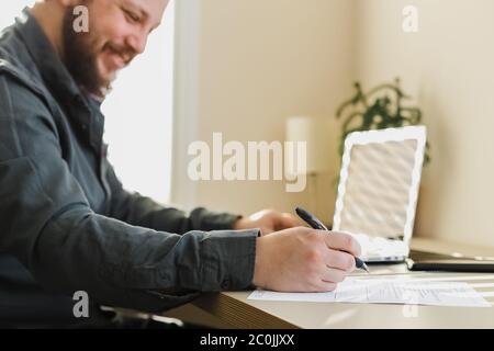 Manager writing letter of resignation and using laptop. Stock Photo