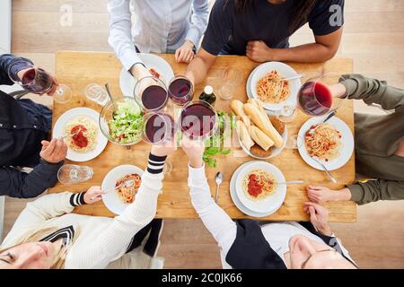 Group of friends over lunch with a glass of red wine Stock Photo