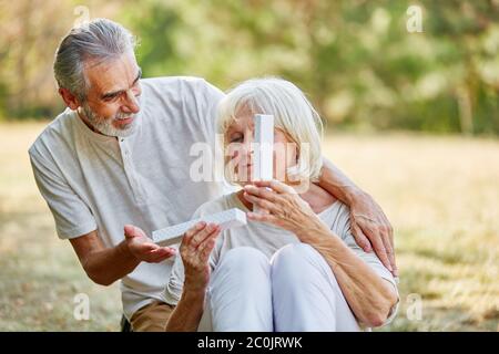 Old man gives his wife a birthday present in the garden Stock Photo