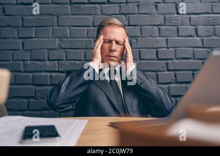 Close up of mature man that having headache Stock Photo