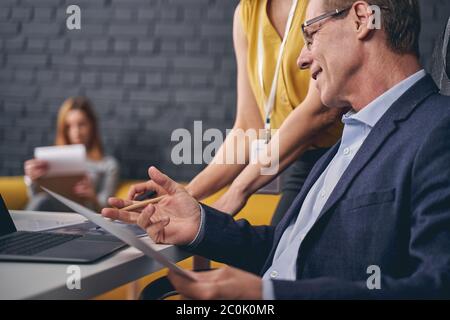 Handsome mature man talking to his assistant Stock Photo
