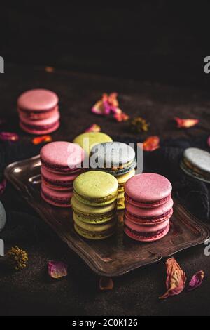 Different types of macaroons on vintage tray on dark background Stock Photo