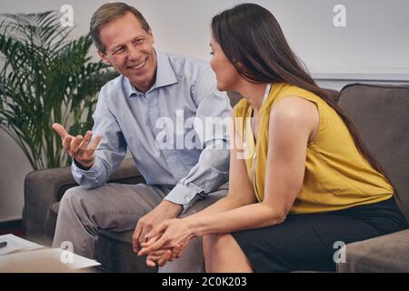 Positive delighted people talking about business project Stock Photo
