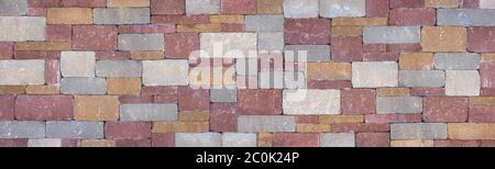 Colored wall made of square, gray, ocher and red stones Stock Photo