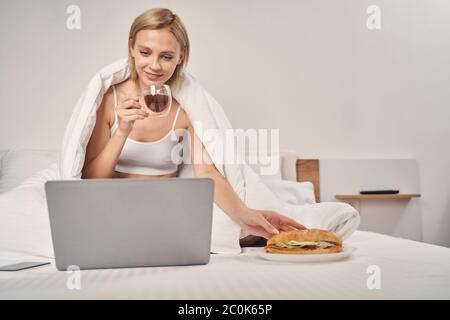 Pleased lady watching her favorite series online Stock Photo