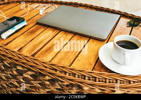 top view of the workspace with a laptop, on a brown wooden table with a smartphone a cup of coffee and a notebook. business concept. Remote work. Copy Stock Photo