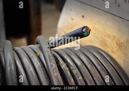 Spool of dusty power cable with edge section showing its copper wire strands Stock Photo