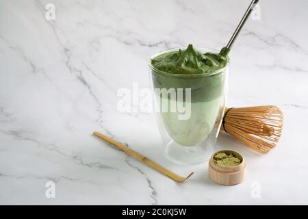 Green matcha dalgona. Trendy hipster drink on marble background. Stock Photo