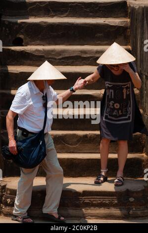 Two persons with hat climbing down stairs Stock Photo