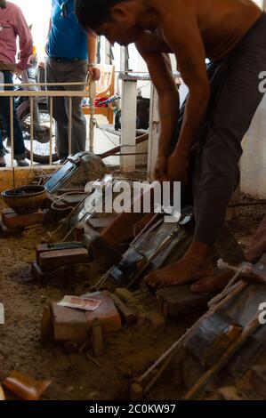 Young craftsman punching gold with a hammer Stock Photo