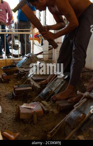 Young craftsman punching gold with a hammer Stock Photo