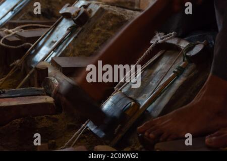 Close up of Young craftsman punching gold with a hammer Stock Photo