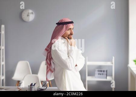 Pensive serious arabic man looks in a white office Stock Photo