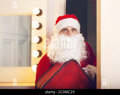 Photo of Santa Claus looking at camera coming to the door Stock Photo