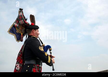 Her Majesty The Queen's Piper, Pipe Major Richard Grisdale, of The Royal Regiment of Scotland, on top of the Round Tower at Windsor Castle, joining pipers and musicians in marking the Battle of St Valery-en-Caux, where he played the pipers' march Heroes of St Valery to commemorate the thousands of Scots who were killed or captured during 'the forgotten Dunkirk' 80 years ago.