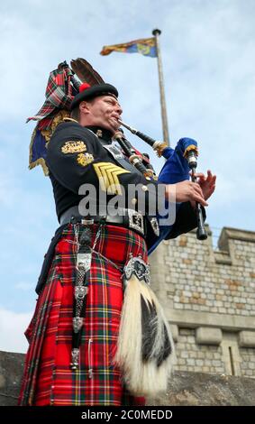 Her Majesty The Queen's Piper, Pipe Major Richard Grisdale, of The Royal Regiment of Scotland, on top of the Round Tower at Windsor Castle, joining pipers and musicians in marking the Battle of St Valery-en-Caux, where he played the pipers' march Heroes of St Valery to commemorate the thousands of Scots who were killed or captured during 'the forgotten Dunkirk' 80 years ago.
