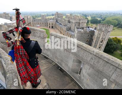 Her Majesty The Queen's Piper, Pipe Major Richard Grisdale, of The Royal Regiment of Scotland, on top of the Round Tower at Windsor Castle, joining pipers and musicians in marking the Battle of St Valery-en-Caux, where he played the pipers' march Heroes of St Valery to commemorate the thousands of Scots who were killed or captured during 'the forgotten Dunkirk' 80 years ago. Stock Photo