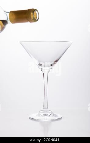 White wine pouring in a glass from bottle Stock Photo