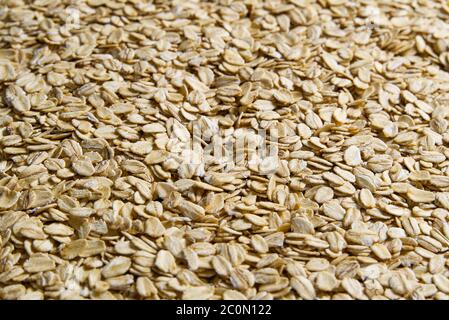 Oatmeal flakes close up as background. Close up of porridge oats as background or texture. Diet and healthy nutrition. Stock Photo