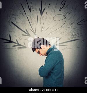 Upset introvert person looking down troubled, feels dismayed. Lonely guy experiencing emotional crisis. Man being under pressure at workplace as multi Stock Photo