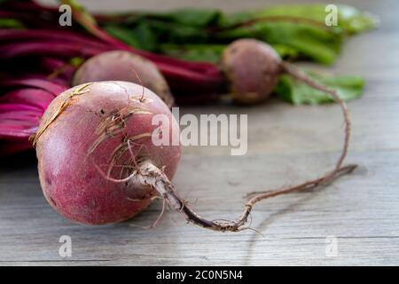 Raw red beetroots on wooden table Stock Photo