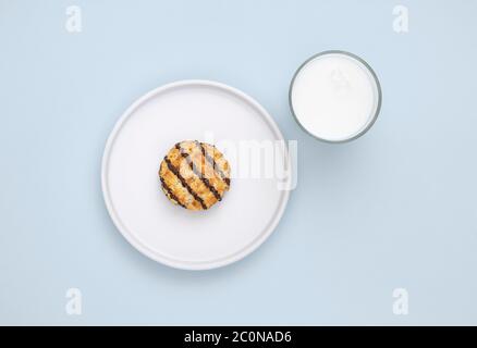 Coconut cookie and a glass of dairy free milk on plain pale blue background Stock Photo