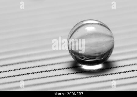 small glass ball on striped paper Stock Photo