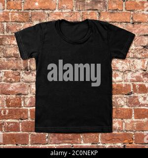 Black blank t-shirt on dark brick background Stock Photo
