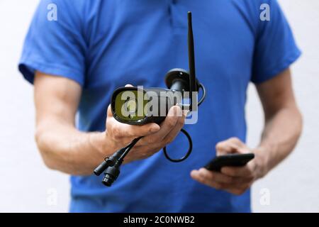 security cameras and cctv services - technician with ip camera in hand Stock Photo