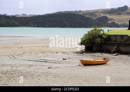 Raglan, beach scene with solitary anchored boat at low tide on Wallis Street. State Highway 23. West Coast North Island, New Zealand. No people Stock Photo