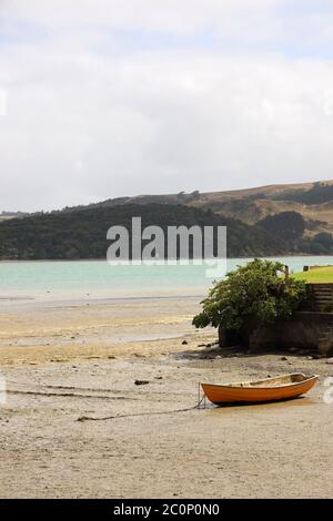 Raglan, beach scene with solitary anchored boat at low tide on Wallis Street. State Highway 23. West Coast North Island, New Zealand. No people Stock Photo