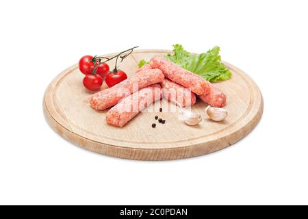Fresh raw chicken minced meat cevapi ready for preparation decorated with cherry tomato, garlic, lettuce and pepper on wooden board. Fresh raw Barbeque Stock Photo