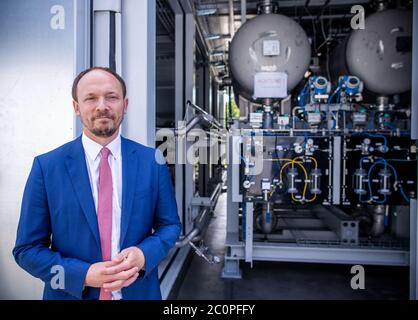 Laage, Germany. 12th June, 2020. Marco Wanderwitz (CDU), Parliamentary State Secretary at the Federal Ministry of Economics and Energy, is standing in front of the fuel cell in what the company says is Europe's largest grid-connected hydrogen power plant at Apex Energy. From autumn 2020, Apex Energy will supply green energy for industry and commerce, housing companies, public transport or for the temporary storage of control energy. Up to 300 tons of hydrogen can be produced annually from exclusively renewable energy sources. Credit: Jens Büttner/dpa-Zentralbild/dpa/Alamy Live News Stock Photo