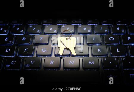 Keys on blue backlit laptop keyboard. Computer security concept. Stock Photo
