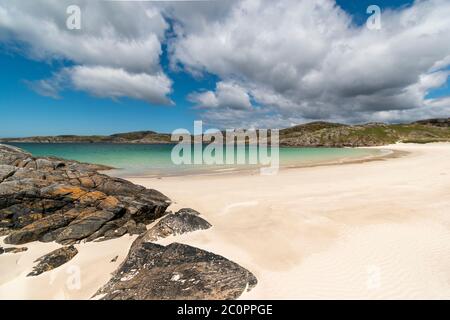 ACHMELVICH BAY AND BEACH SUTHERLAND HIGHLANDS SCOTLAND BLUE  SKY WHITE SAND AND THE COLOURS OF THE SEA Stock Photo